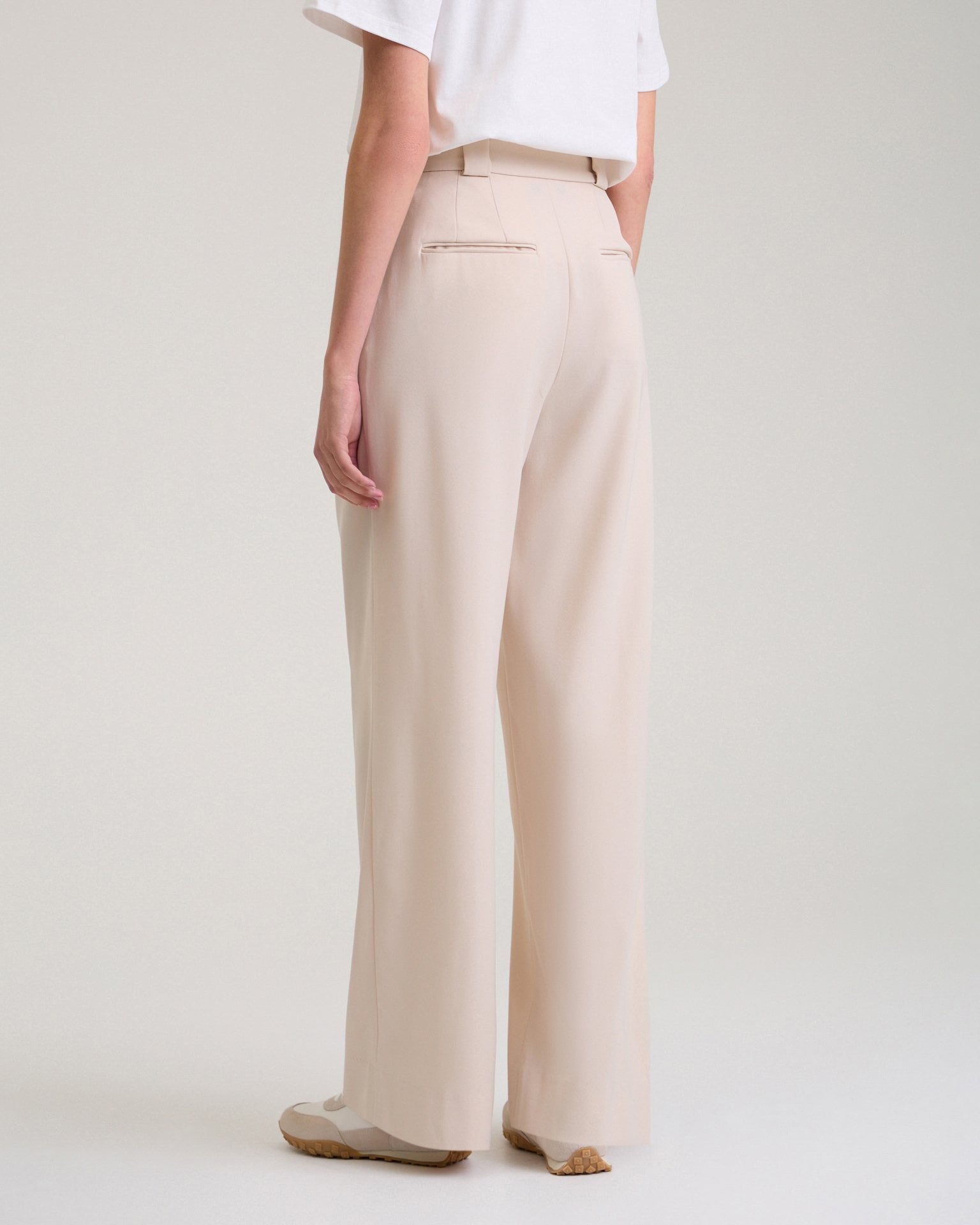 Trousers with a decorative pocket in beige